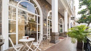 A hotel lobby with marble flooring, white chairs, and a large window overlooking the street. - Collection O Emerald Luxury Apartment - Near SECC (Ho Chi Minh City)
