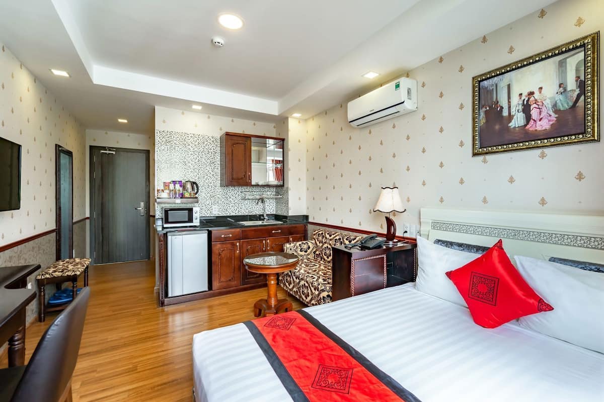 Een hotelkamer met een bed, een bureau, een stoel, een kleine tafel, een magnetron, een wastafel en een kast.