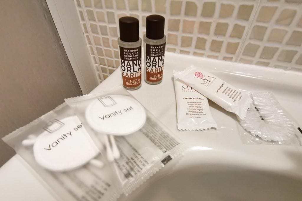 Wastafelset met een shampoofles, fles conditioner, tandenborstel, tandpasta en scheermesje.