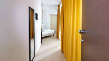 Una habitación de hotel con una cama, una mesita de noche y un espejo.