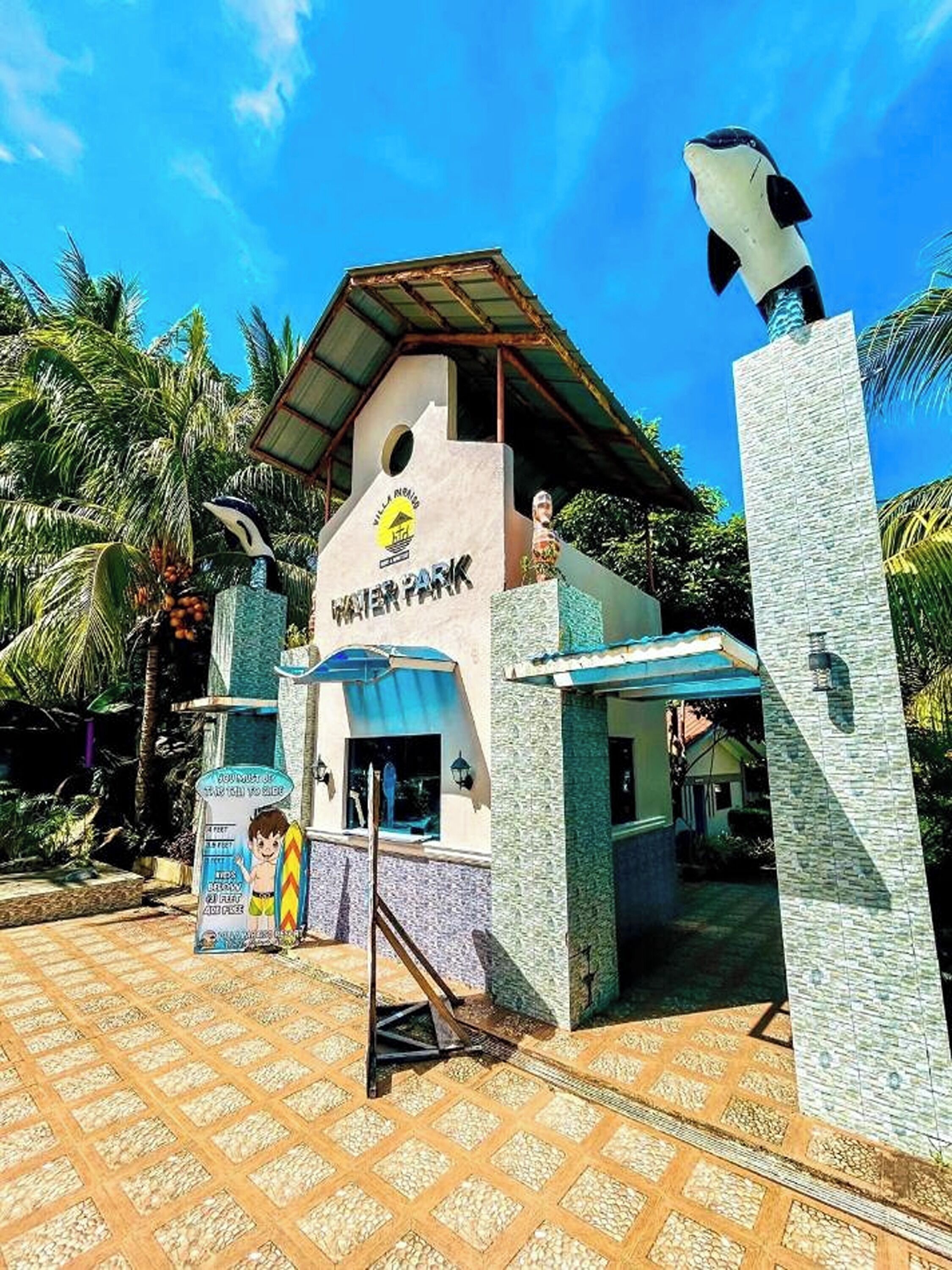 A water park entrance with a sign reading "Water Park" and a lifeguard statue.