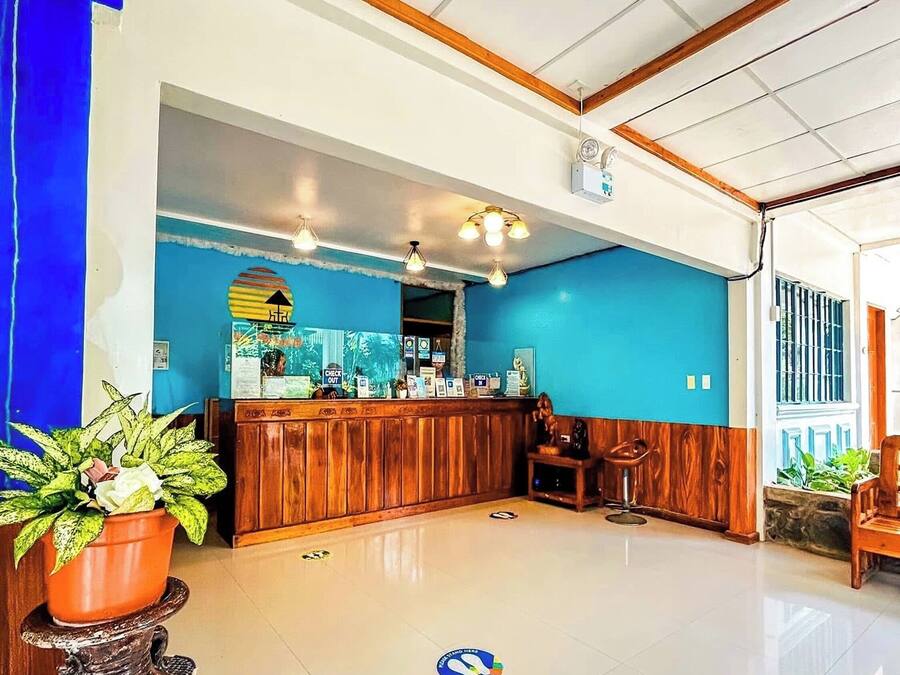 A reception area with a wooden counter, a blue wall, and a tiled floor.