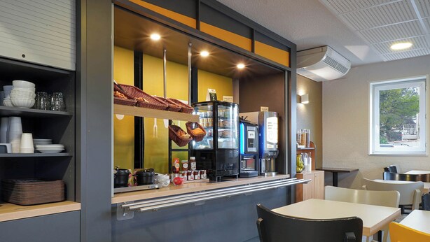 A cafe with a counter, seating area, and a window. - B&B HOTEL AIX EN PROVENCE Pont de l'Arc (Aix-en-Provence)