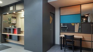 A modern reception area with a desk, chairs, and a counter. - B&B HOTEL AIX EN PROVENCE Pont de l'Arc (Aix-en-Provence)