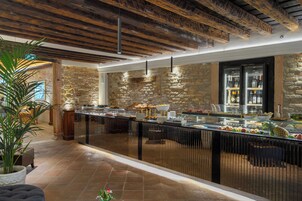Un'area buffet con pareti in pietra, una vetrina in vetro che espone cibi e un soffitto in legno.