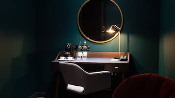 A modern room with a desk, chair, and a round mirror.