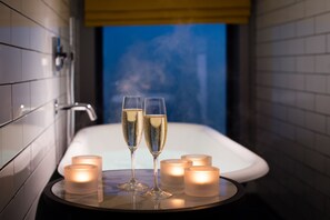 A bathtub with two champagne glasses and four candles. - Hotel Du Vin Stratford Upon Avon (Stratford-upon-Avon)