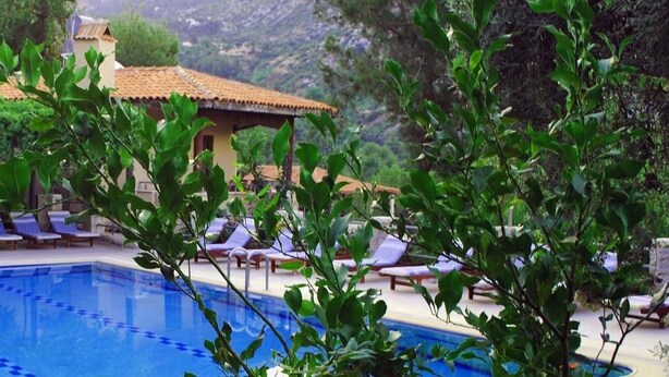 Una piscina al aire libre de temporada, sombrillas