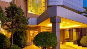 Un edificio moderno con una amplia fachada de vidrio y un diseño de sol distintivo en el piso superior.