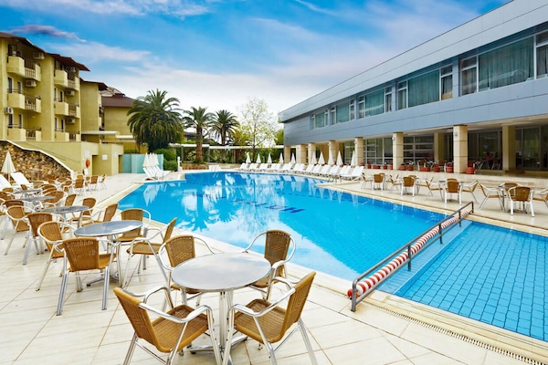 Alberca techada, alberca al aire libre y sombrillas en la alberca