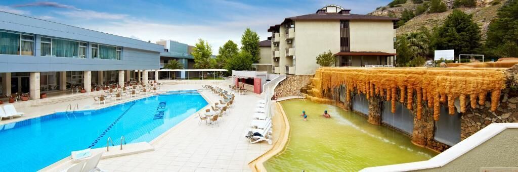 A swimming pool with lounge chairs and a waterfall feature.