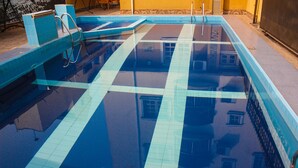 A swimming pool with tiled edges and a ladder. - Banex Hotel and Suites (Lagos)