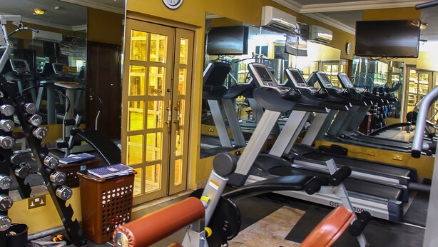 A gym with treadmills, weight machines, and a mirrored wall. - Banex Hotel and Suites (Lagos)