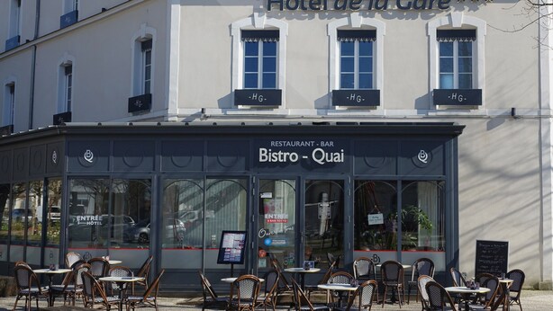 A restaurant named Bistro-Quai with outdoor seating, a sign for Hotel de la Gare, and a clear view of the entrance. - Hôtel de la Gare (La Roche-sur-Yon)