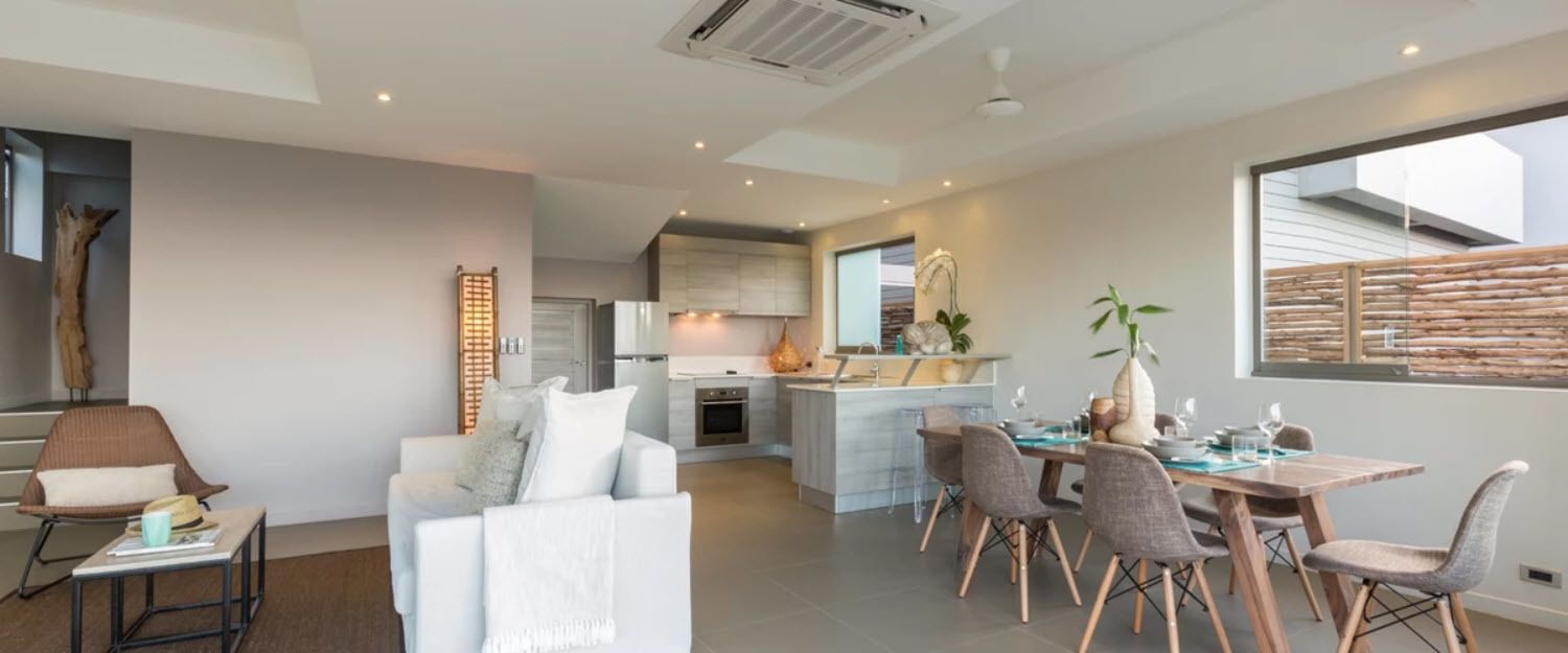 Una sala moderna con comedor, una cocina al fondo y un ventanal con vistas.