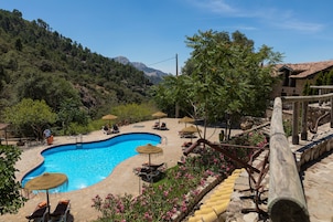 Una piscina al aire libre de temporada, sombrillas