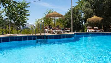 Een seizoensgebonden buitenzwembad, parasols voor strand/zwembad