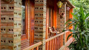 A traditional wooden building with a balcony, featuring a brick wall with circular cutouts and a wooden railing. - Ninh Binh Mountain View Homestay (Tay Hoa Lu)