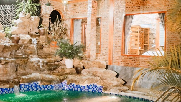 A two-story building with a swimming pool, a waterfall, and a balcony. - Ninh Binh Mountain View Homestay (Tay Hoa Lu)