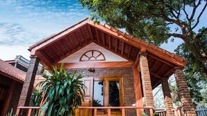 A traditional brick building with a wooden balcony and large windows. - Ninh Binh Mountain View Homestay (Tay Hoa Lu)