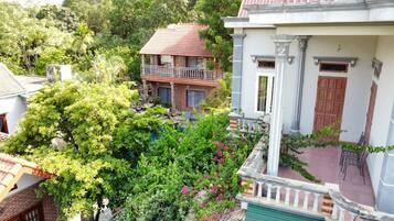 Un quartiere residenziale con una casa dotata di balcone, un piccolo giardino e una piscina.