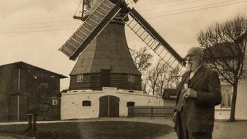 A windmill with a large, open structure and a person standing in front of it.