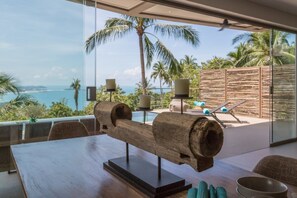 Enjoy a panoramic ocean view from the large window, with a comfortable seating area and outdoor space to relax.