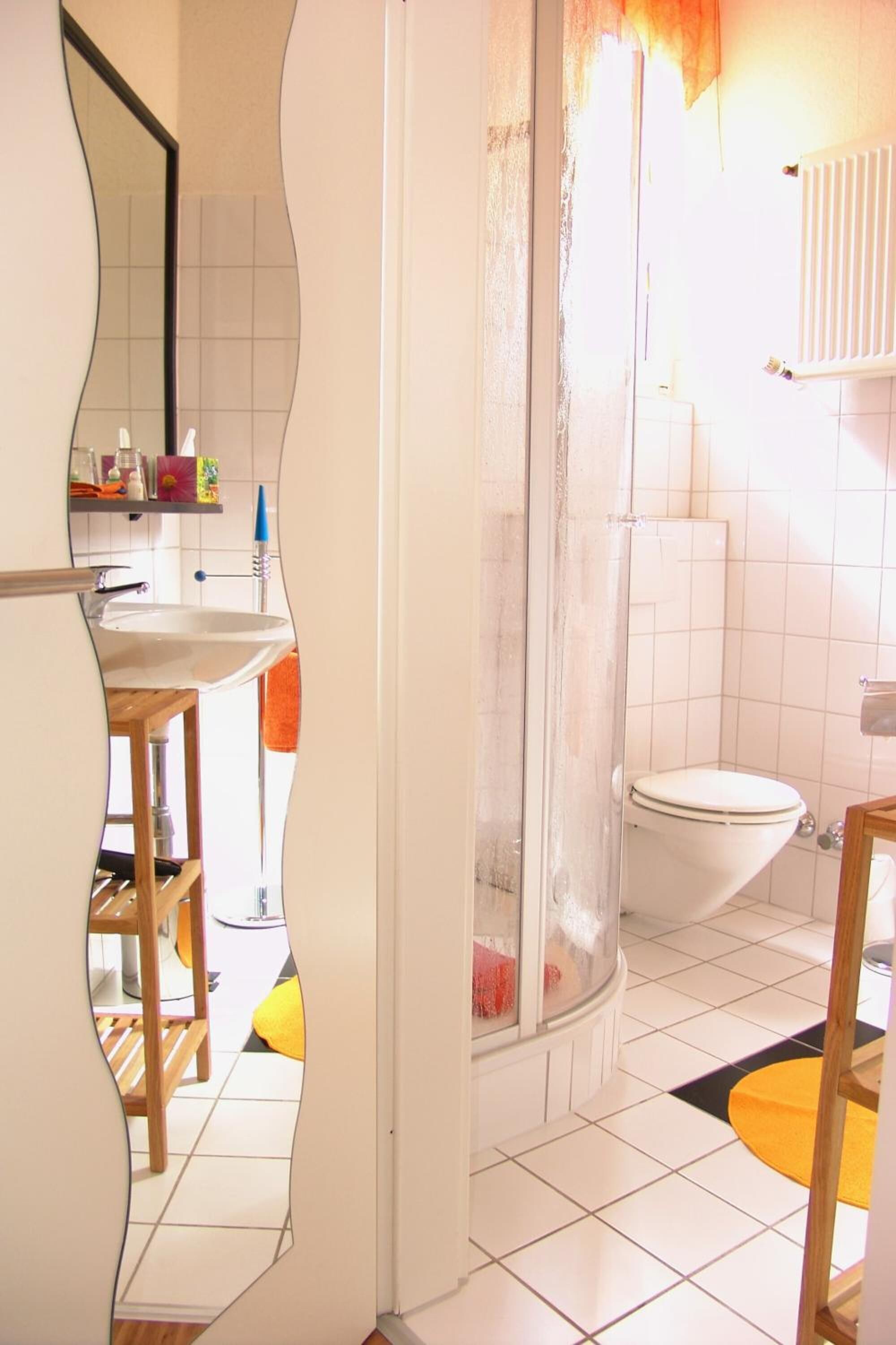 A bathroom with a shower, toilet, and sink.