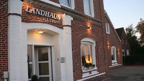 A brick building with a sign reading "LANDHAUS Uttum". - Landhaus Uttum (Krummhoern)