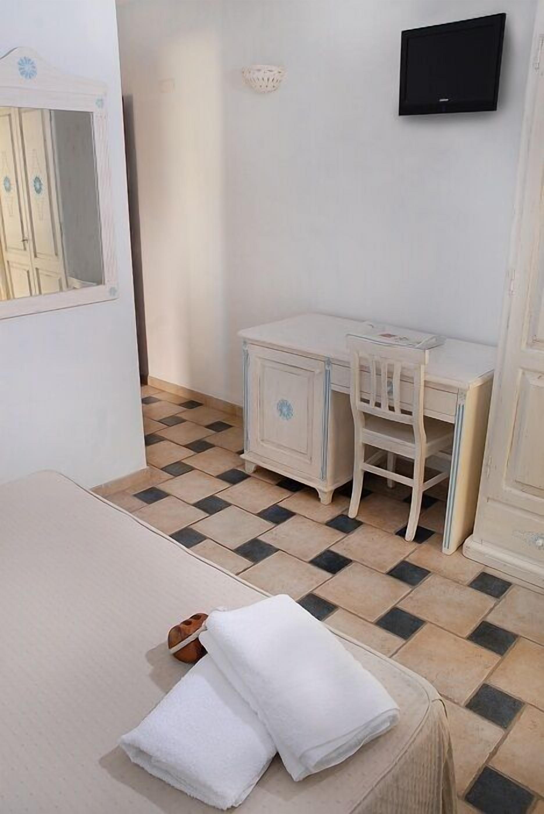 A room with a bed, a desk, and a chair.