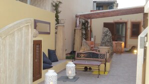 An outdoor seating area with a bench, two decorative lanterns, and a potted plant. - Hotel Patti (Golfo Aranci)