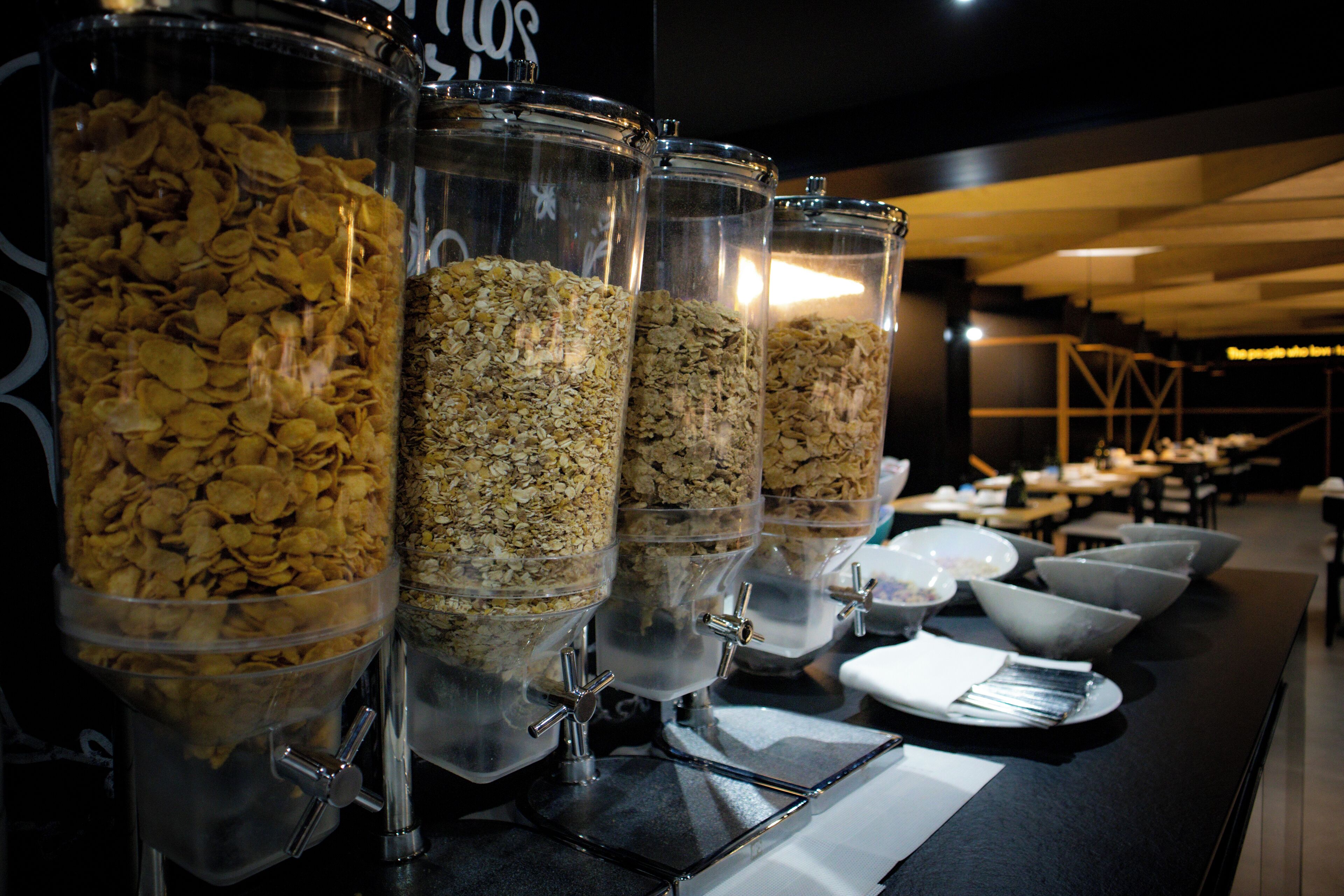 Montaje de bufé con varios recipientes de cereales y granola.