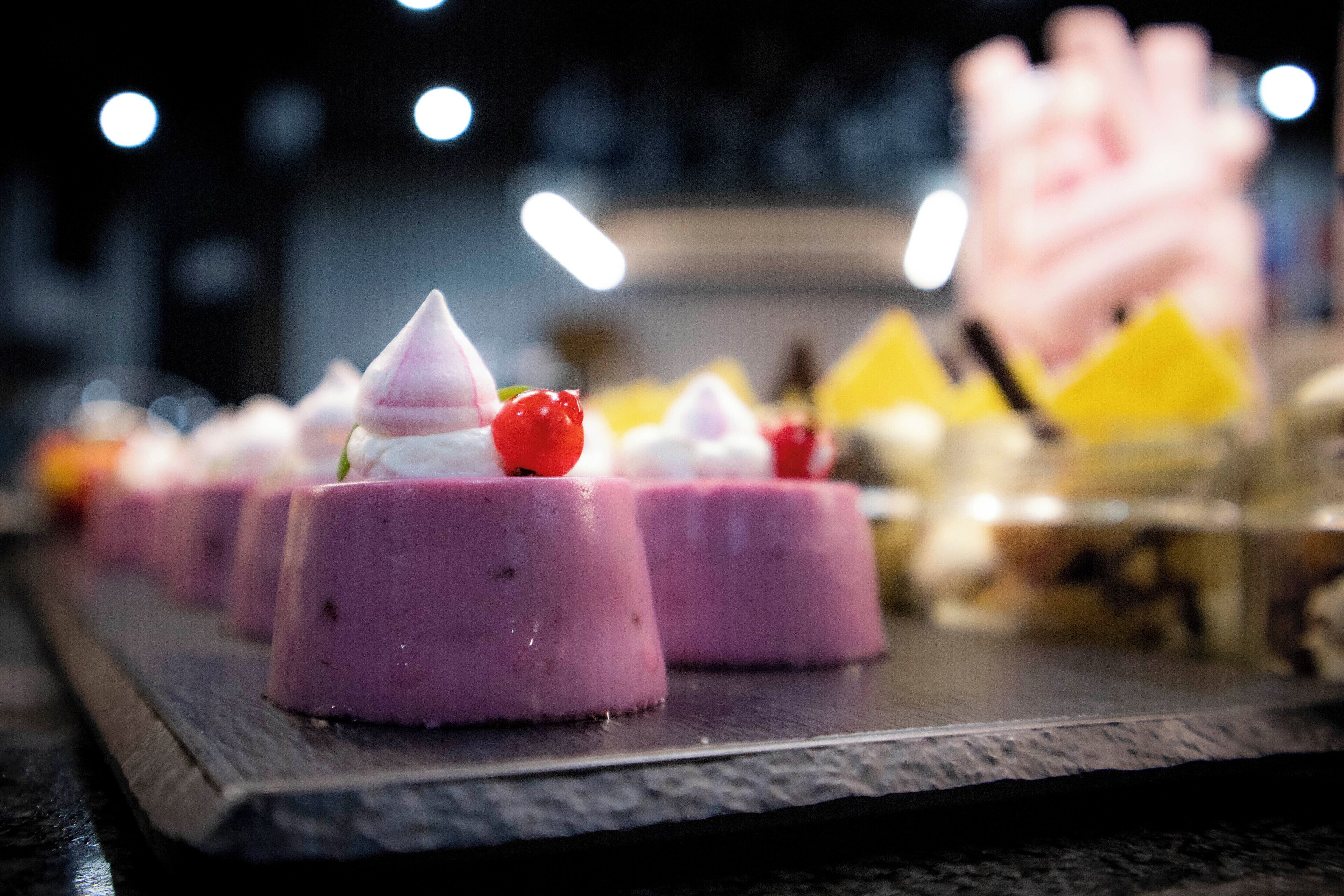 Una presentación de postres con diversas golosinas coloridas sobre una tabla de madera.