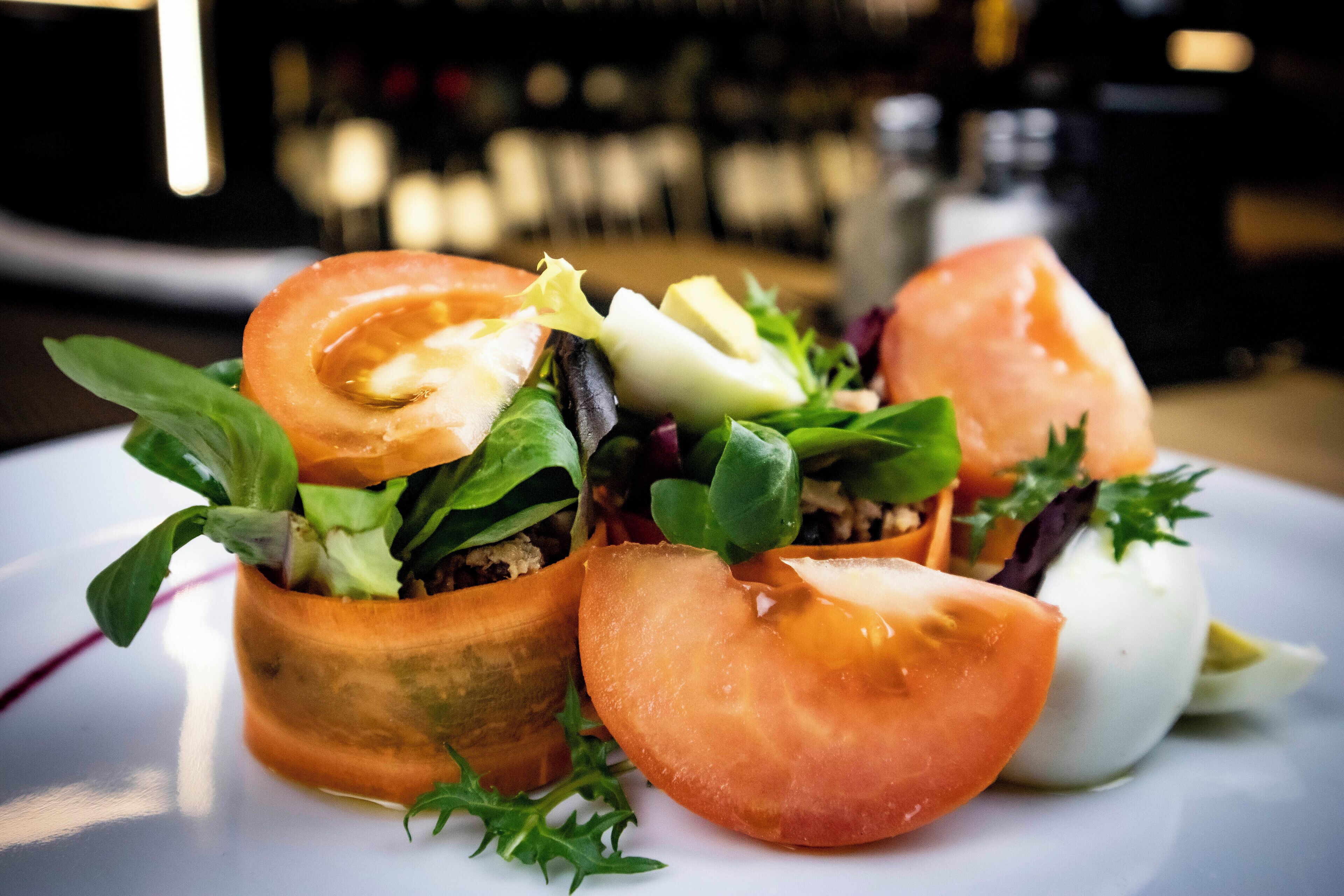 Un plato con ensalada de tomates, verduras y queso.