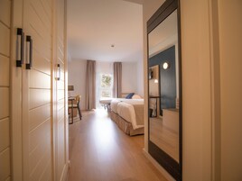 Habitación de hotel con cama, escritorio y silla. Cuenta con una ventana con cortinas y vistas al exterior.
