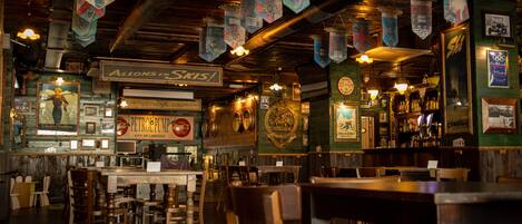 A bar with wooden furniture and hanging decorations.