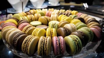 En glaskasse med farverige macarons arrangeret i et cirkulært mønster.