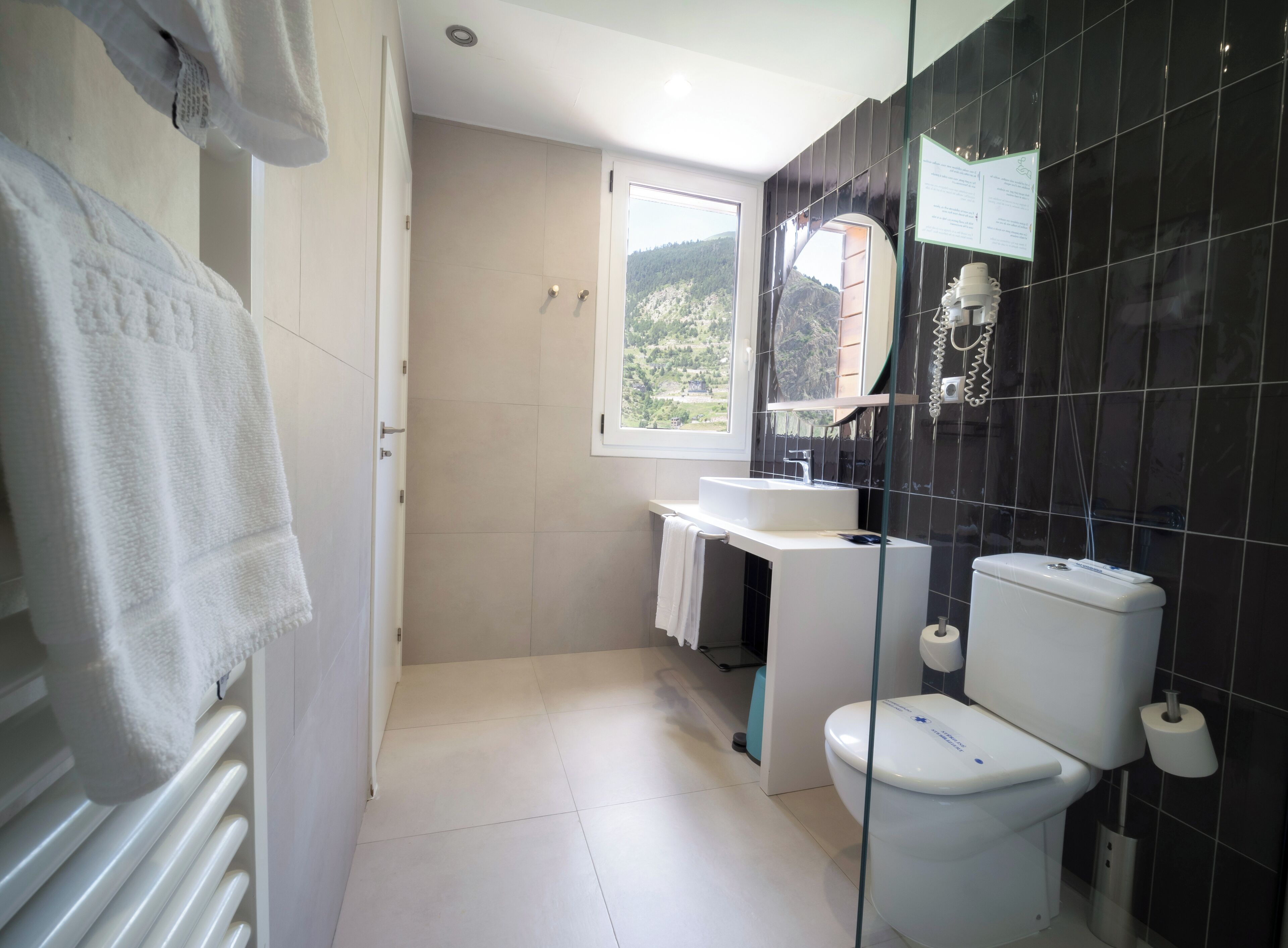 Un baño moderno con inodoro, lavamanos y ducha.