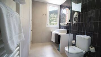Un baño moderno con inodoro, lavamanos y ducha.