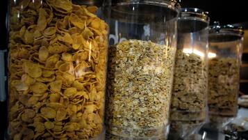 A row of transparent containers filled with various grains and cereal flakes.