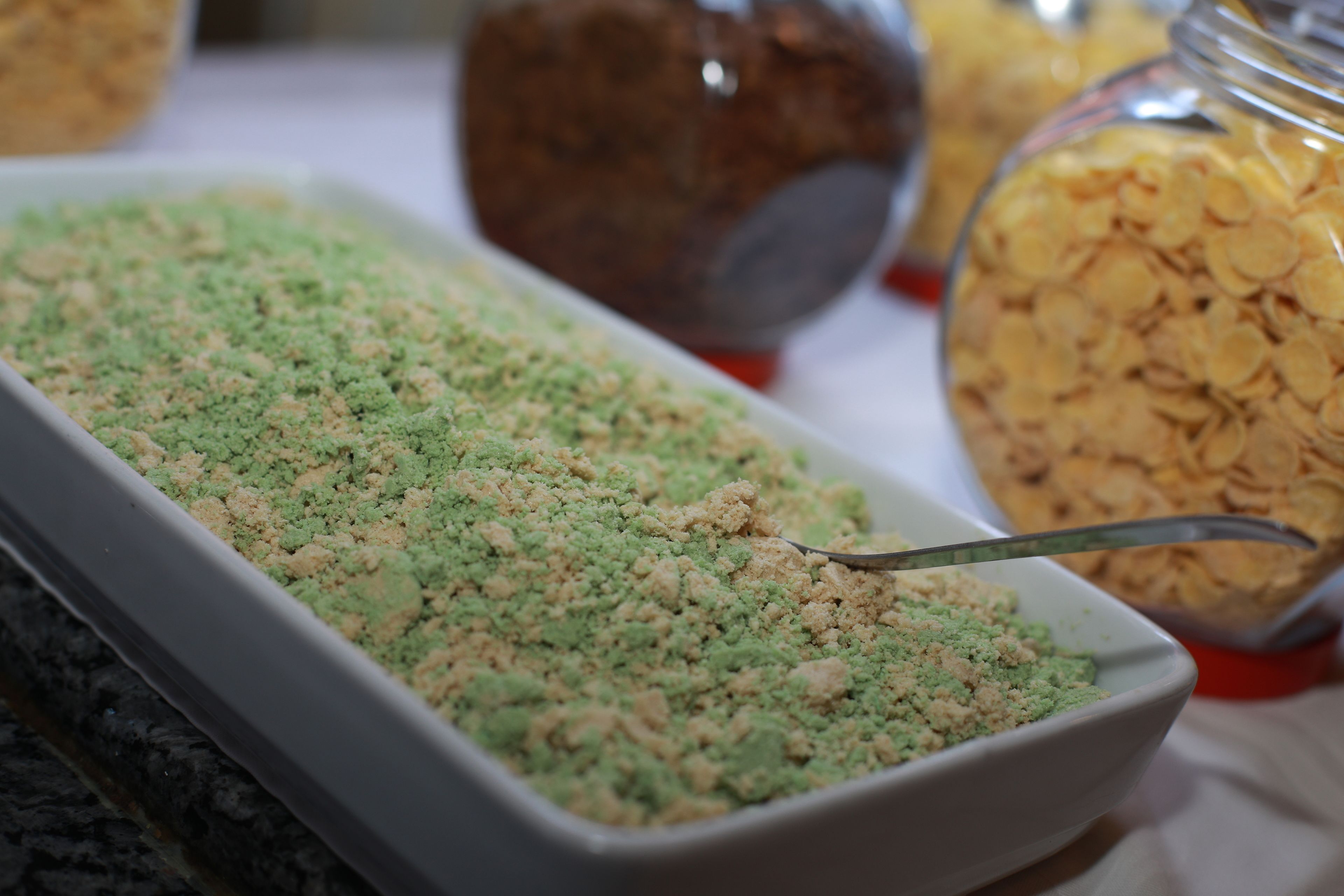 Uma bandeja de granola colorida com uma colher.