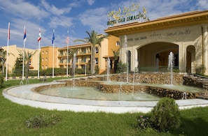 Hotel Dar Ismail with a fountain, flags, and a stone pathway. - Hotel Dar Ismail Tabarka (Tabarka)