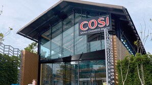 Un edificio moderno con fachada de vidrio y un letrero que dice "COSI SAMUI CHAWENG BEACH".