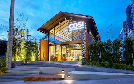 A modern building with a glass facade and a sign reading "COSI Sangkawit Beach".