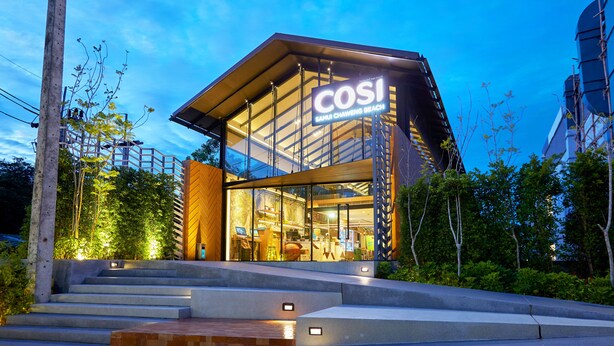 Un edificio moderno con fachada de vidrio y un letrero que dice "COSI Sangkawit Beach".