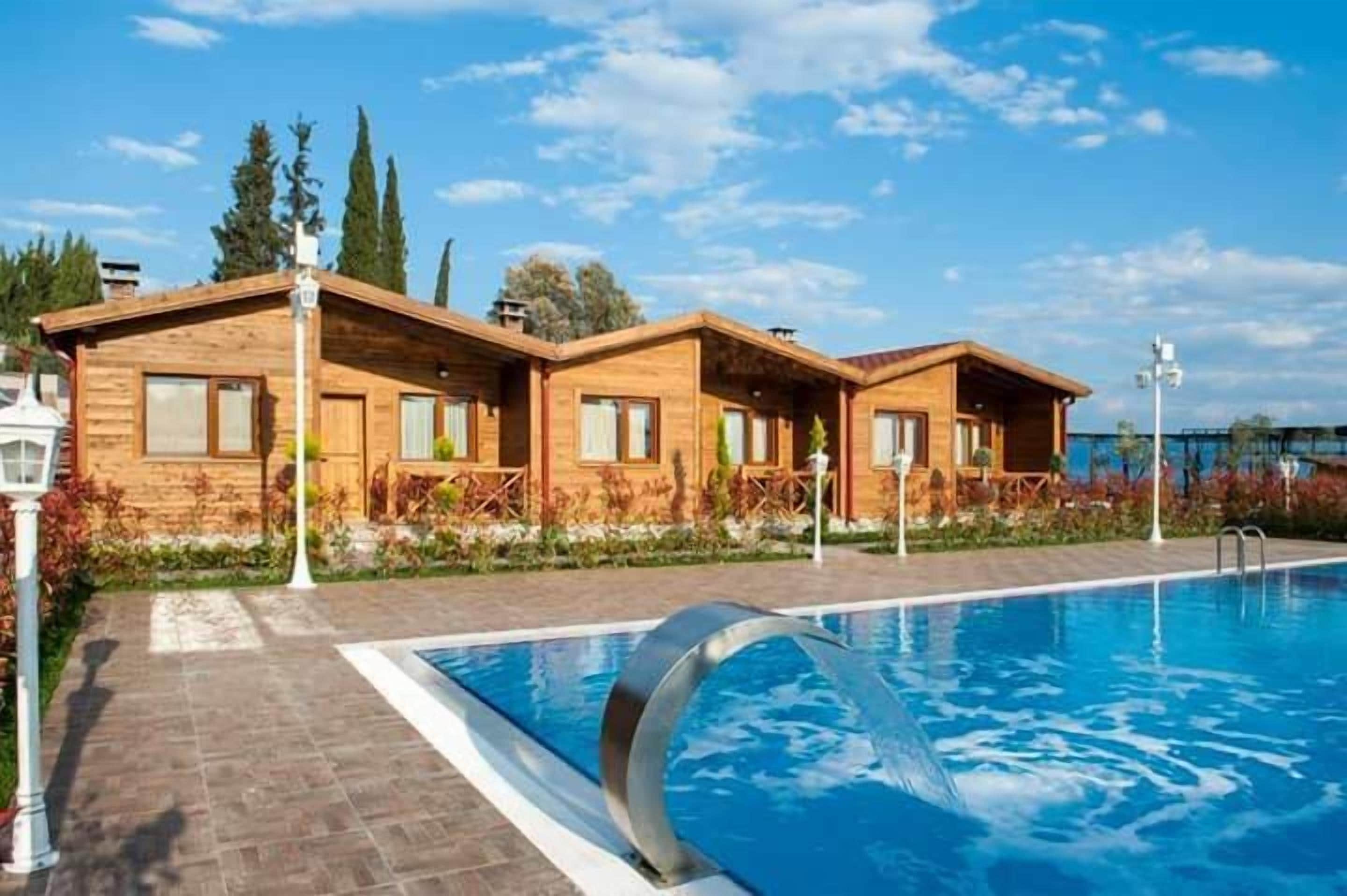 Un hotel con estilo de cabaña de madera y una piscina.