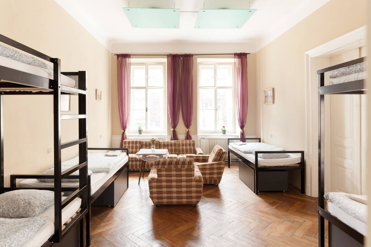 Une chambre de dortoir avec des lits superposés, un canapé et une table à manger.