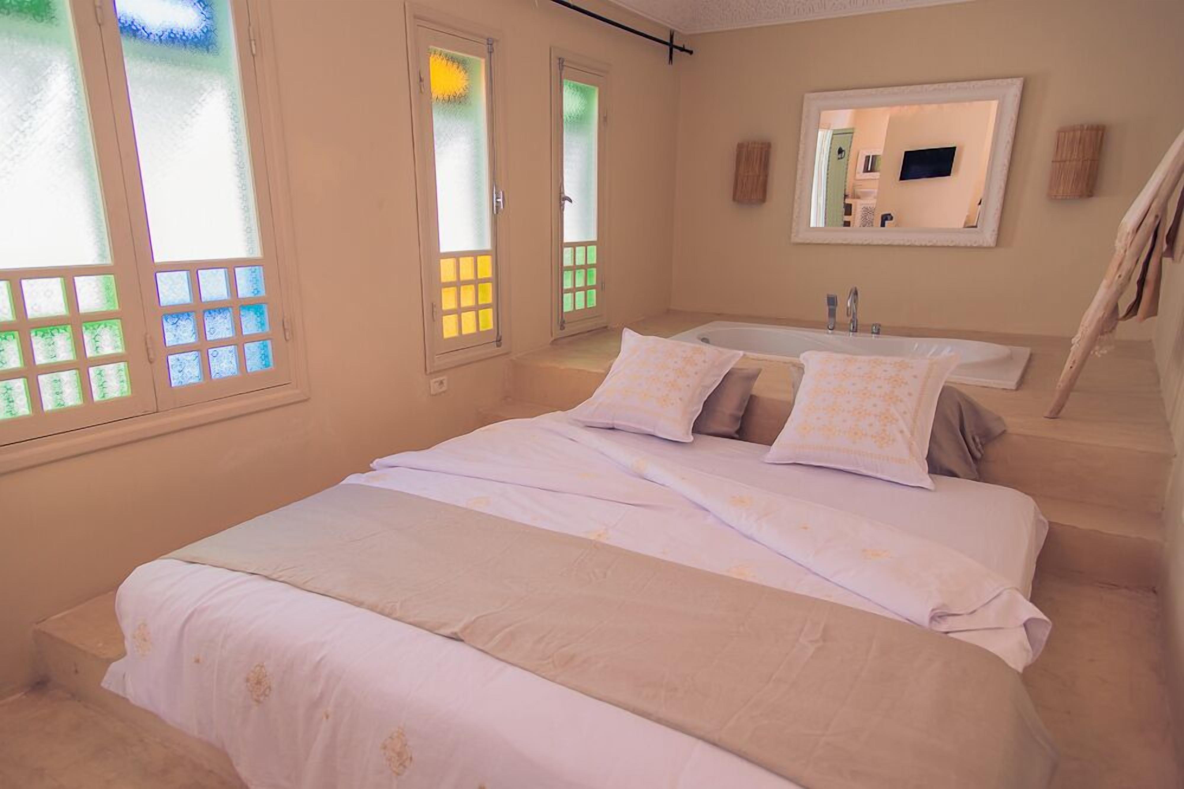 A bedroom with a bed, a bathroom, and a staircase.