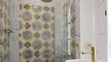 Un baño moderno con ducha, lavabo y espejo.