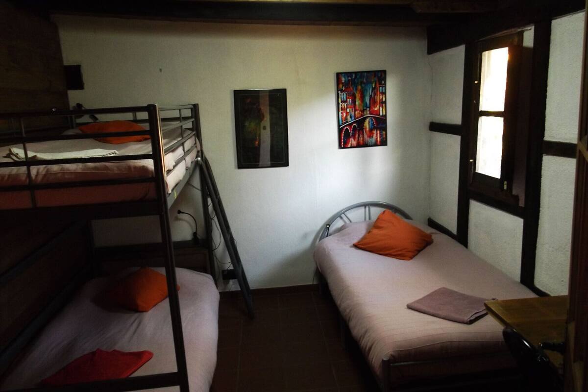 Un dormitorio con literas, una cama individual y un ventanal con vistas.